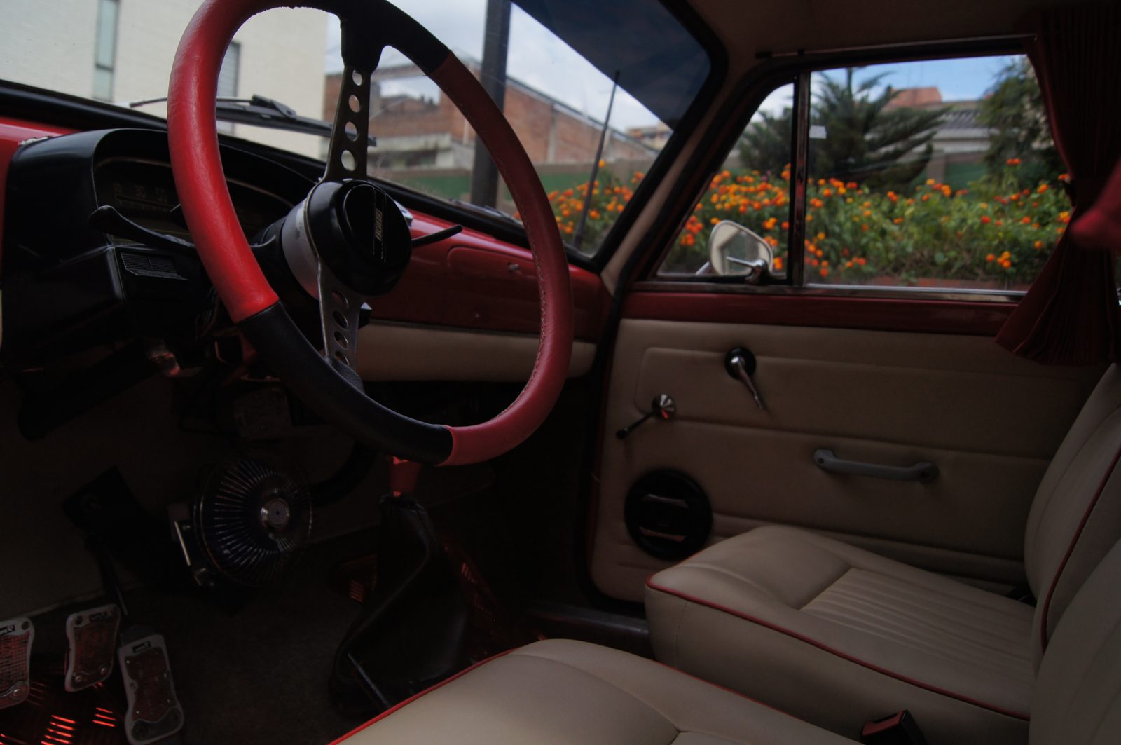 Interior rojo deportivo — volante MOMO y asientos en cuero crema